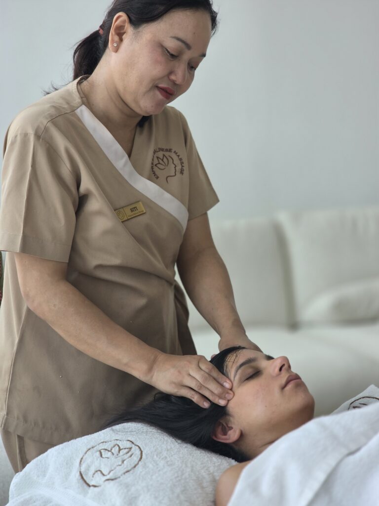 Empress therapist giving a relaxing head massage to a client