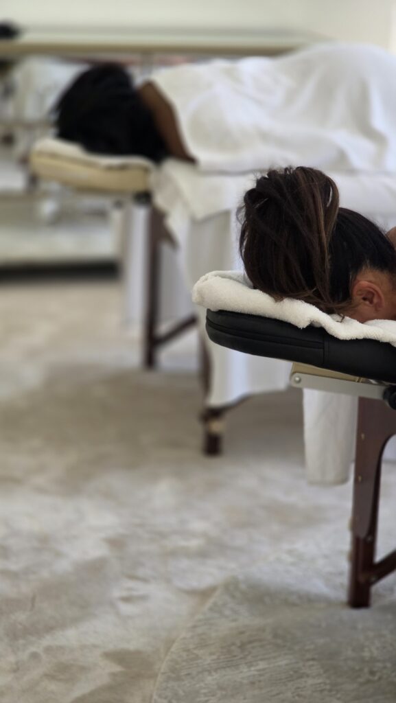 Two clients receiving a couple massage side by side at home