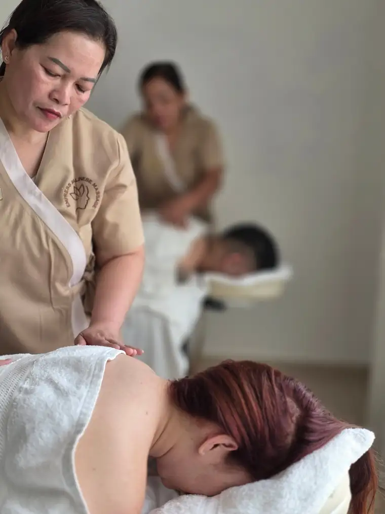 Two Balinese therapists giving a couples massage at home in Dubai