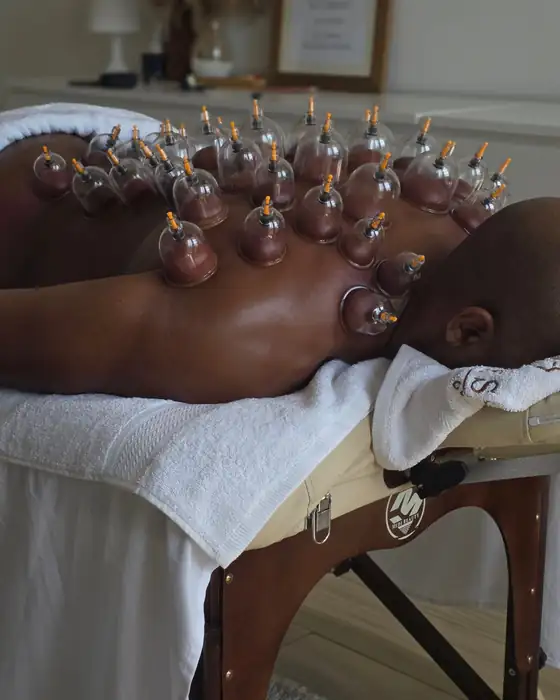 Cupping therapy cups along the back and shoulders during a home massage in Dubai