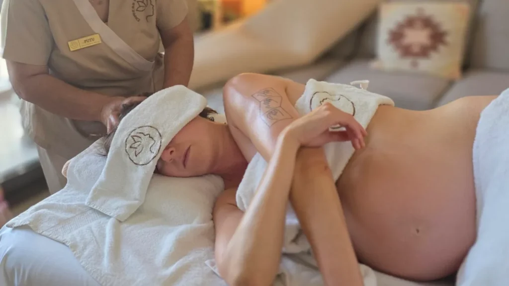 Pregnant client relaxing side-lying during an Empress prenatal massage at home in Dubai