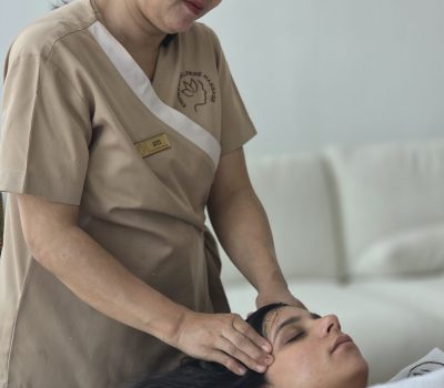 asian woman lying on her back whilst having a head masage
